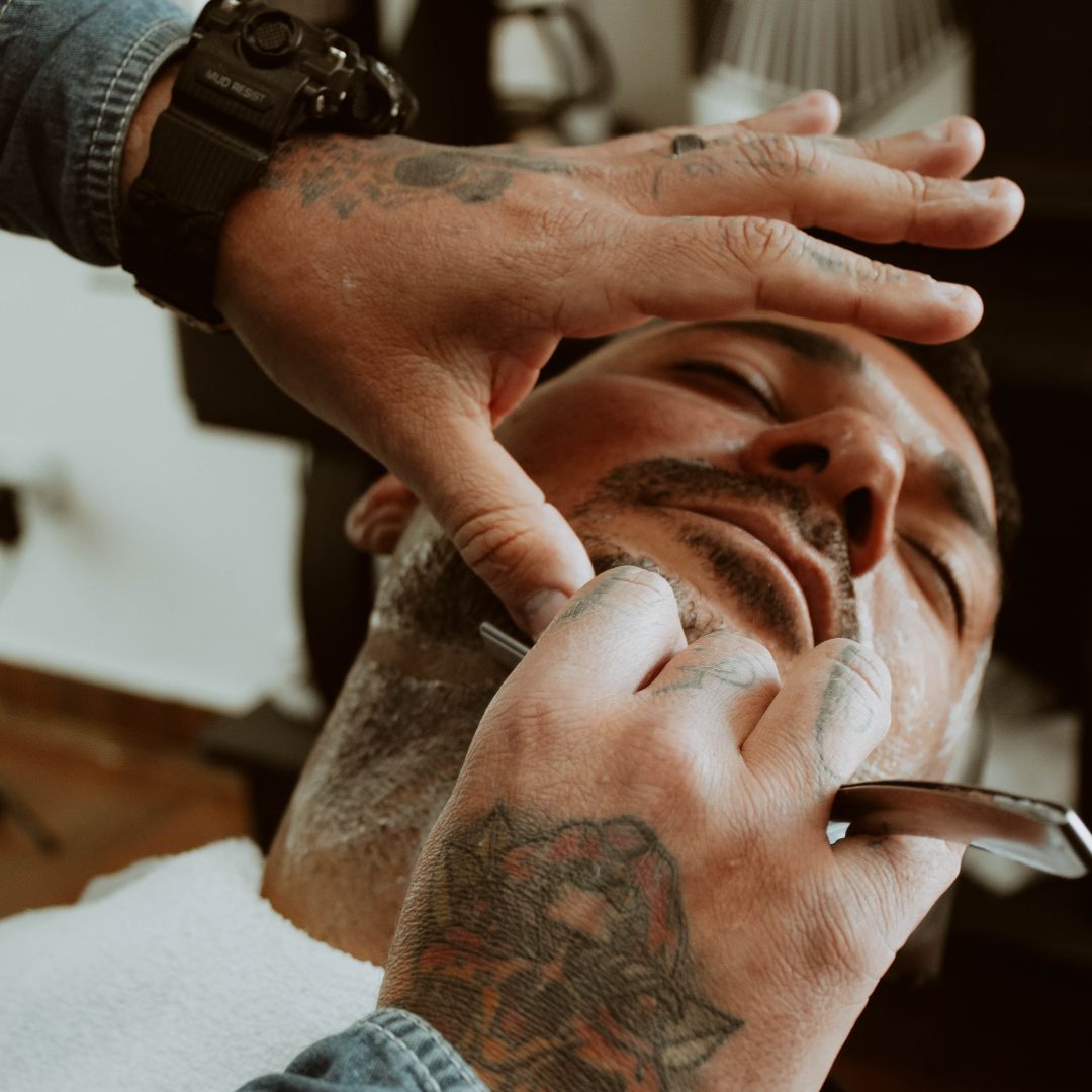 hombre en barbería siendo afeitado